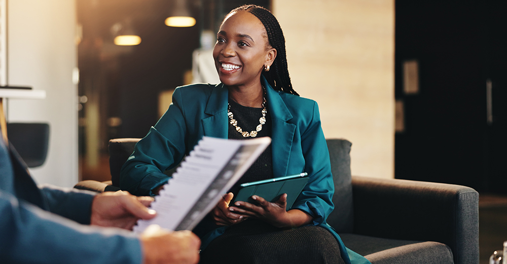 Collaboration, meeting and tablet with business woman in lobby of office for discussion or proposal. Documents, smile and presentation with employee in workplace for partnership, report or research